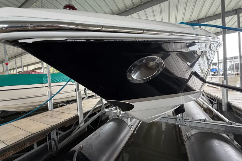 Slide: The Image of 2012 Cobalt 242 boat docked in a covered marina, showcasing sleek black and white hull design. - 5