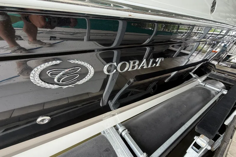 Slide: The Image of 2012 Cobalt 242 boat with sleek black exterior and chrome logo detailing. - 6