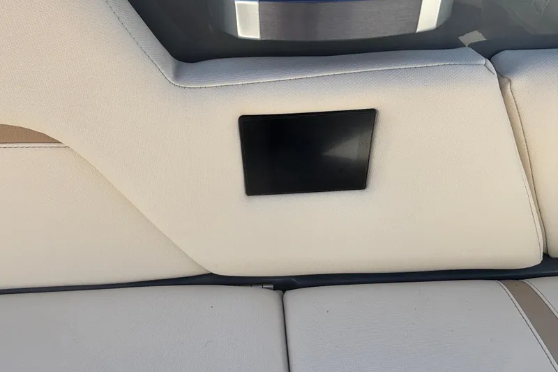 Slide: The Image of 2022 MasterCraft X26 boat interior with beige upholstery and a black panel. - 11