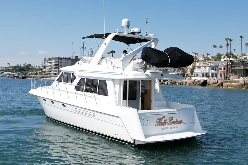 Slide: The Image of 2007 Navigator 44 Classic yacht cruising near coastal homes and palm trees. - 2