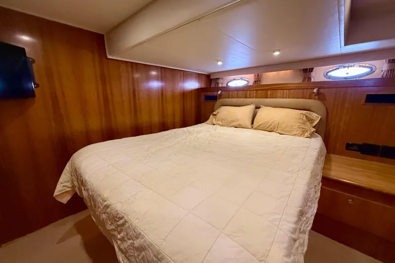Slide: The Image of Luxurious bedroom interior of 2007 Navigator 44 Classic yacht with wood paneling and cozy bedding. - 23