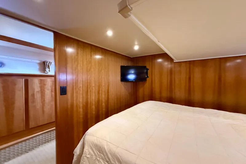 Slide: The Image of Cozy bedroom interior of 2007 Navigator 44 Classic yacht with wood paneling and mounted TV. - 24
