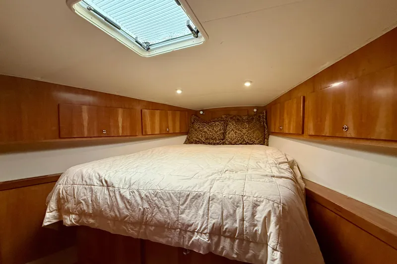 Slide: The Image of Cozy cabin bedroom in 2007 Navigator 44 Classic yacht with wood paneling and skylight. - 29
