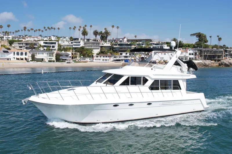 Slide: The Image of 2007 Navigator 44 Classic yacht cruising near coastal homes under a clear blue sky. - 6