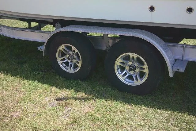 Slide: The Image of Trailer wheels of a 2019 Sea Fox 248 Commander boat on grass. - 13