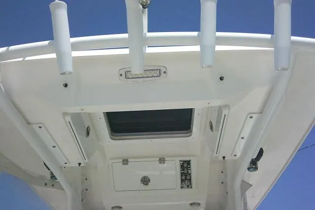 Slide: The Image of 2019 Sea Fox 248 Commander boat roof with rod holders and hatch under clear blue sky. - 54