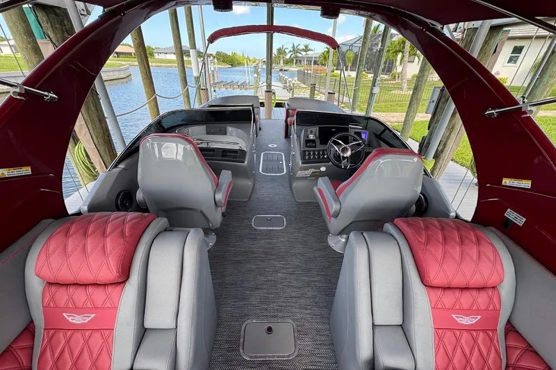 Slide: The Image of Luxurious interior of 2024 Bennington QX27 pontoon boat with red and gray seating. - 17