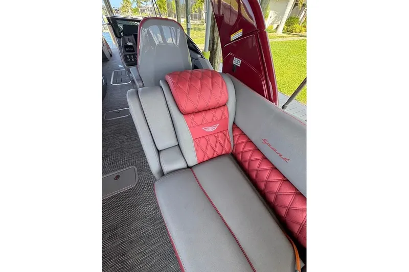 Slide: The Image of Luxurious interior of 2024 Bennington QX27 boat with red and gray quilted seating. - 24