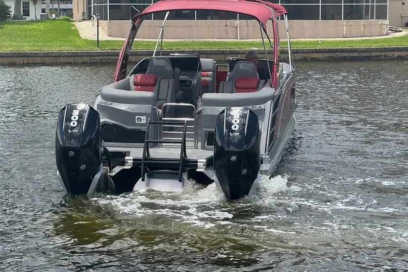 Slide: The Image of 2024 Bennington QX27 pontoon boat with dual 300 V8 engines on a calm waterway. - 31
