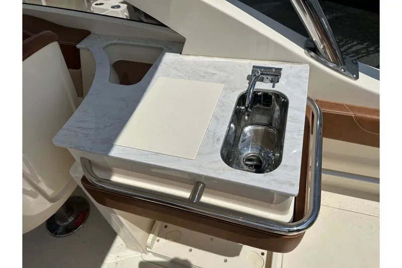 Slide: The Image of The 2021 Scout 235 Dorado features a compact kitchenette with a sink and cutting board. - 19