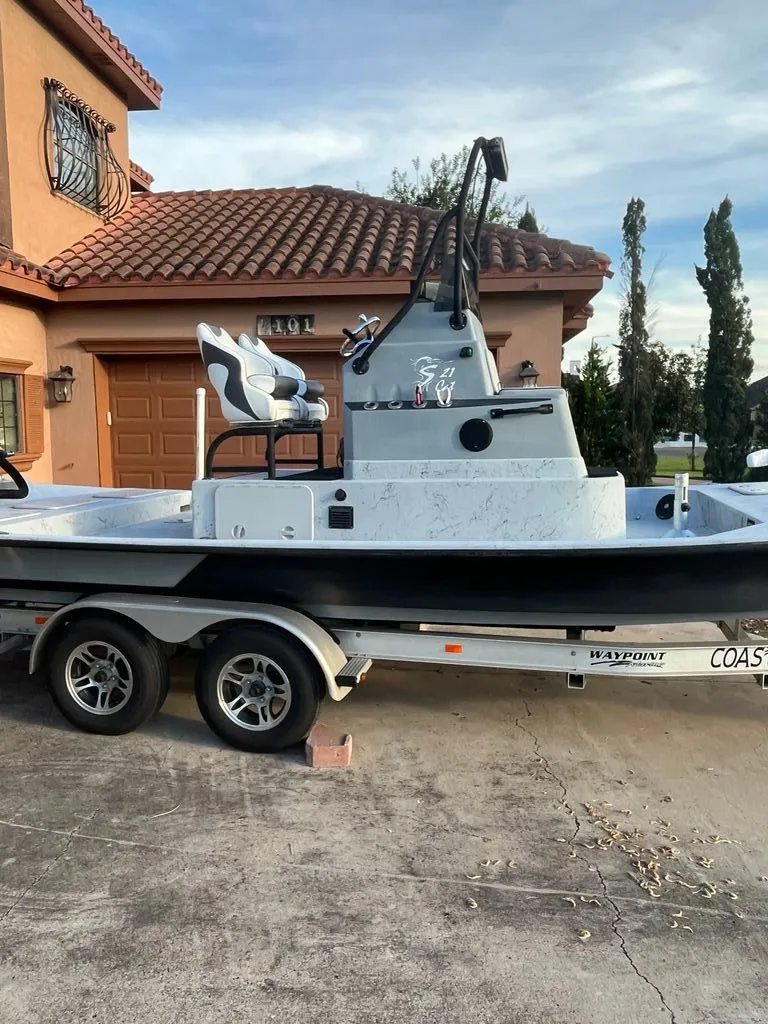 Slide: The Image of 2021 Shoalwater 21' Catamaran on trailer parked in front of house. - 3