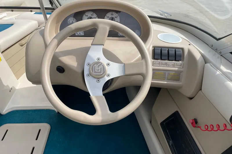 Slide: The Image of Steering wheel and dashboard of a 1995 Glastron SSV 175 boat, featuring gauges and controls. - 10