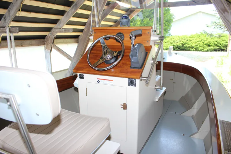 Slide: The Image of Interior of a 2015 Custom Stambaugh Redwing 18' boat with wooden helm. - 21