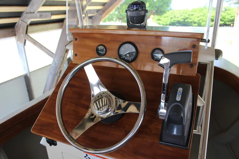 Slide: The Image of Steering console of a 2015 Custom Stambaugh Redwing 18' boat with wooden finish. - 22