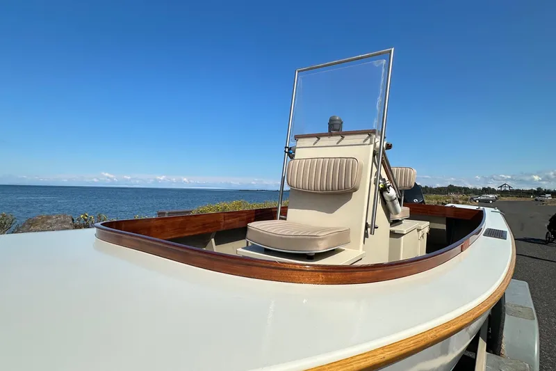 Slide: The Image of Custom Stambaugh Redwing 18' boat, 2015 model, docked by the sea under clear blue skies. - 6