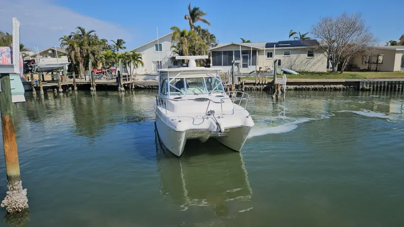 Slide: The Image of 2008 World Cat 320 EC boat navigating a calm residential canal. - 23