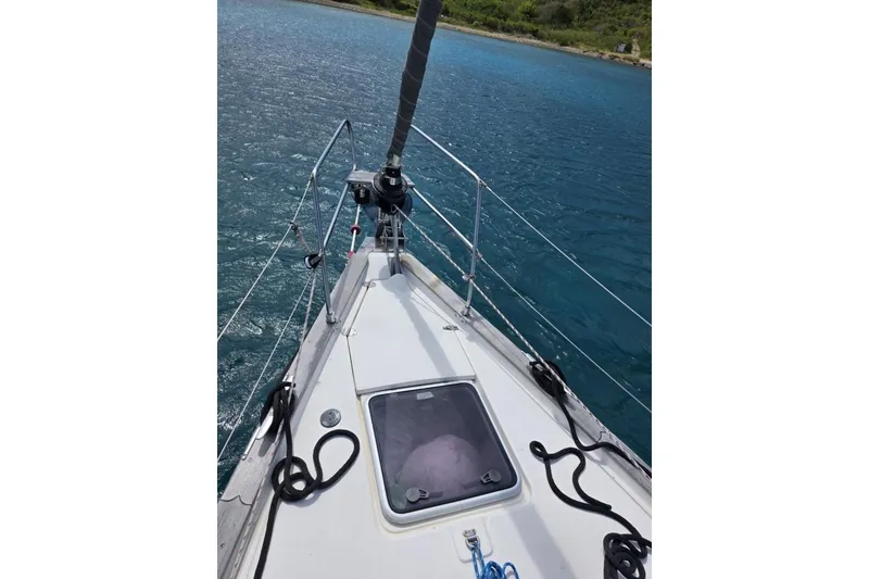 Slide: The Image of Bow of 2003 Bavaria 44 sailboat on clear blue water. - 15