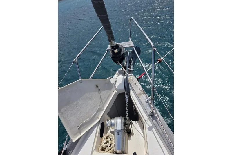 Slide: The Image of Bow of 2003 Bavaria 44 sailboat with anchor chain and winch over blue water. - 16
