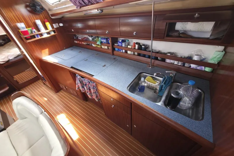 Slide: The Image of Interior of a 2003 Bavaria 44 yacht kitchen with wooden cabinets and dual sinks. - 22