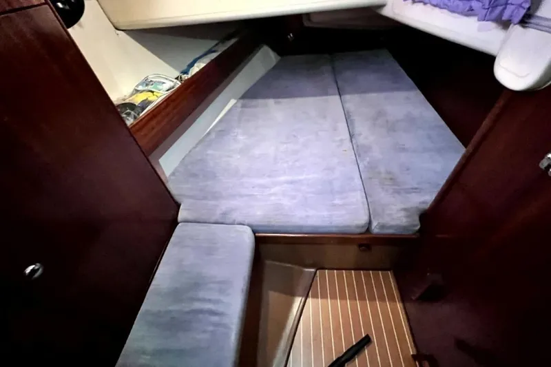 Slide: The Image of Cozy cabin interior of 2003 Bavaria 44 sailboat with blue cushions and wooden accents. - 28