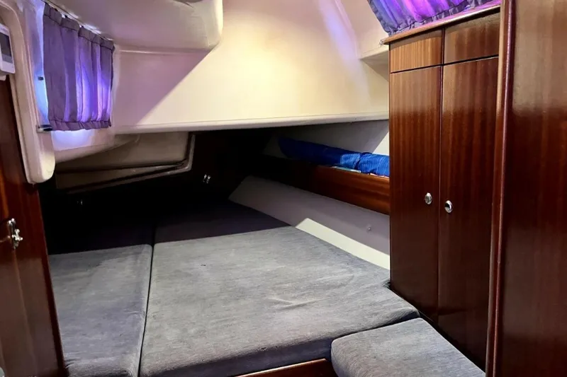 Slide: The Image of Cozy cabin interior of 2003 Bavaria 44 yacht with wooden cabinets and soft lighting. - 29