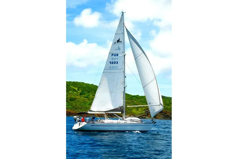 Slide: The Image of Sailing yacht Bavaria 44, 2003 model, cruising on blue ocean near lush green island. - 35