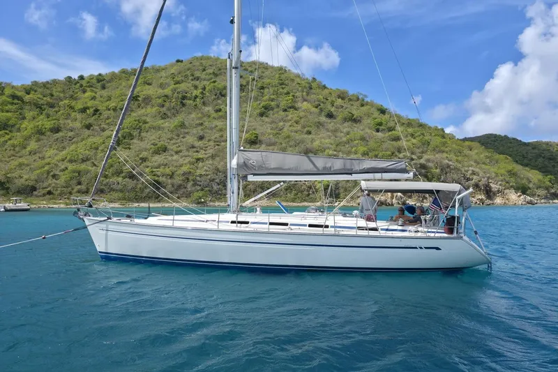 The Image of Sailing yacht Bavaria 44, 2003 model, anchored in clear blue waters near a lush green island. - 5