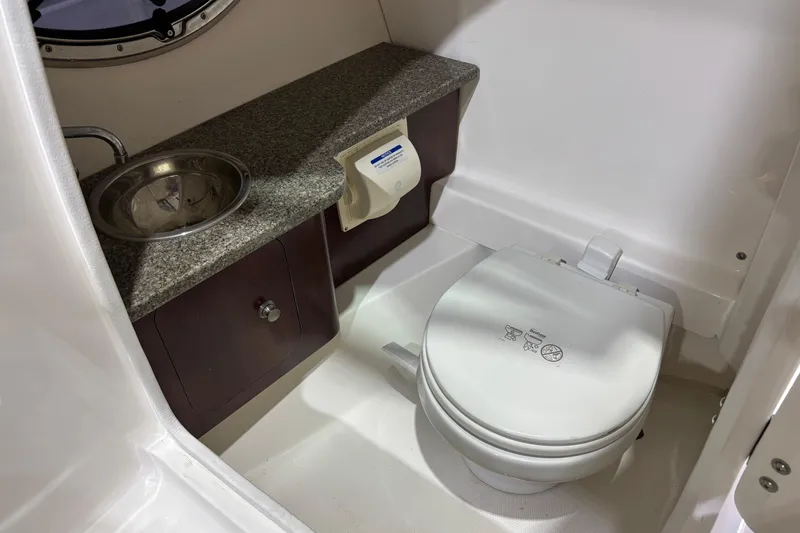 Slide: The Image of 2015 Chaparral 244 Sunesta boat bathroom with sink and toilet. - 13
