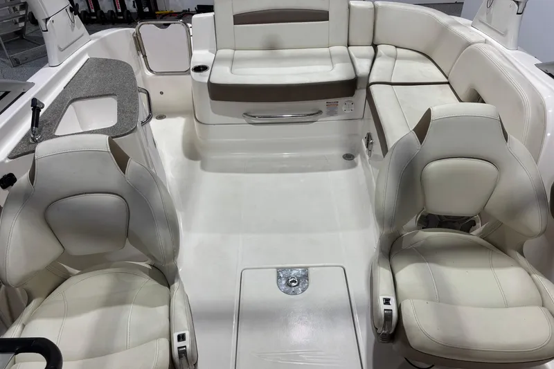 Slide: The Image of 2015 Chaparral 244 Sunesta boat interior with white seating and a small sink area. - 14