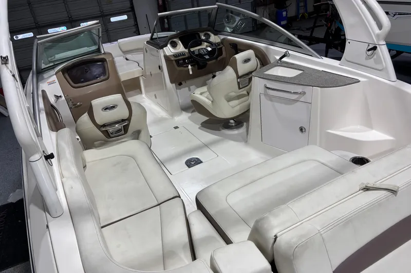 Slide: The Image of Interior of a 2015 Chaparral 244 Sunesta boat, featuring white seating and helm. - 15