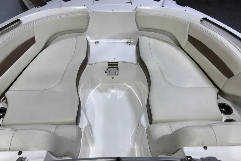 Slide: The Image of Interior seating of a 2015 Chaparral 244 Sunesta boat, featuring white and brown upholstery. - 9