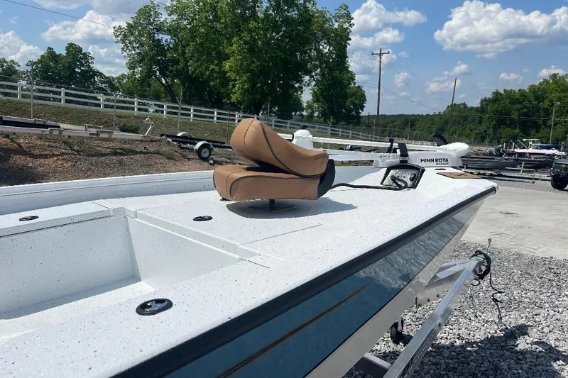 Slide: The Image of 2026 Xpress H20B Bay boat with tan seat, parked outdoors under blue sky. - 5