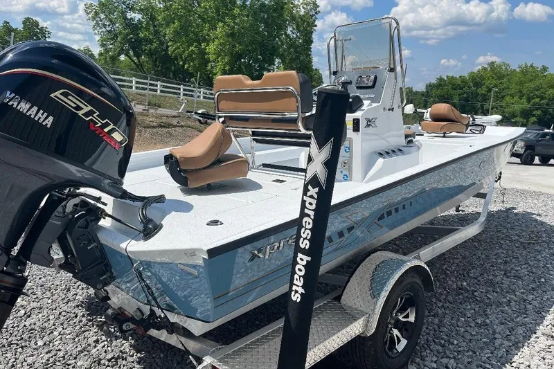 Slide: The Image of 2026 Xpress H20B Bay boat with Yamaha engine on trailer, parked outdoors. - 7