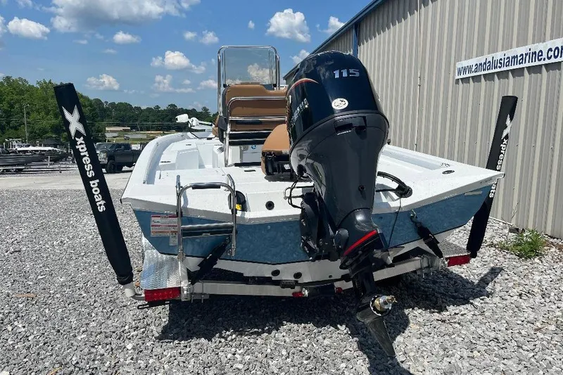 Slide: The Image of 2026 Xpress H20B Bay boat with 115 HP engine, parked on gravel near a marine shop. - 9