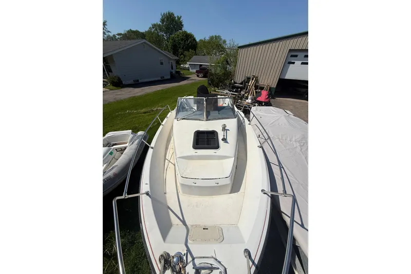 The Image of 1990 Bayliner 2302 Trophy Walkaround boat on trailer, parked outdoors. - 1