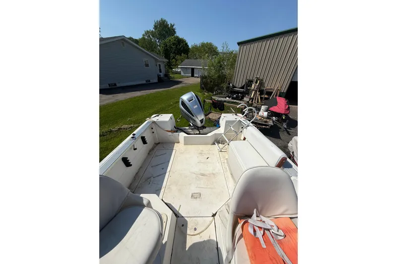 Slide: The Image of 1990 Bayliner 2302 Trophy Walkaround boat interior with seating and outboard motor. - 2