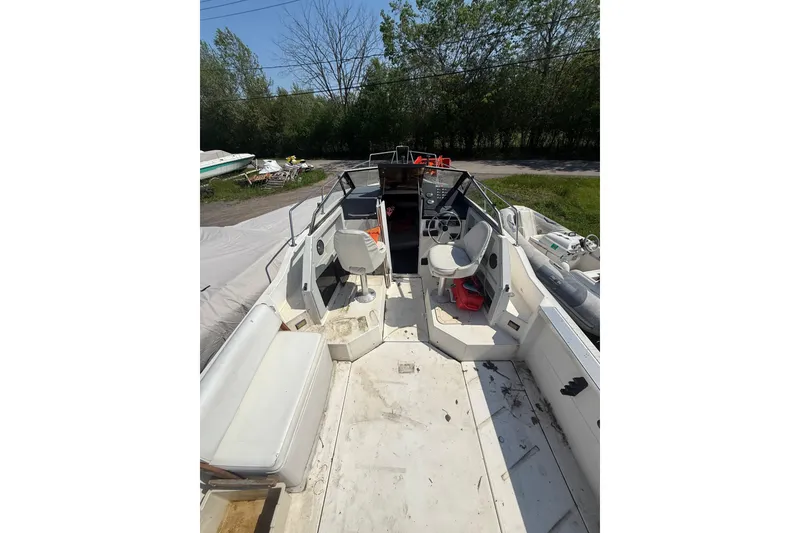 Slide: The Image of 1990 Bayliner 2302 Trophy Walkaround boat interior with seating and steering wheel. - 3