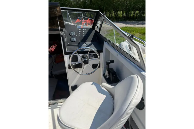 Slide: The Image of 1990 Bayliner 2302 Trophy Walkaround boat interior with steering wheel and control panel. - 4