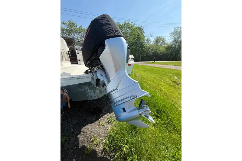 Slide: The Image of Outboard motor on a 1990 Bayliner 2302 Trophy Walkaround, parked on grass. - 7