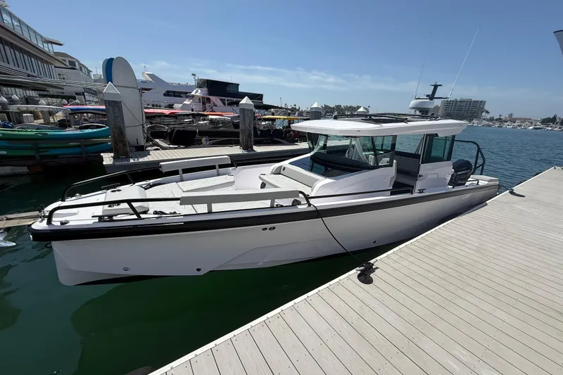 The Image of 2025 Axopar 29 XC Cross Cabin boat docked at a marina under clear skies. - 0