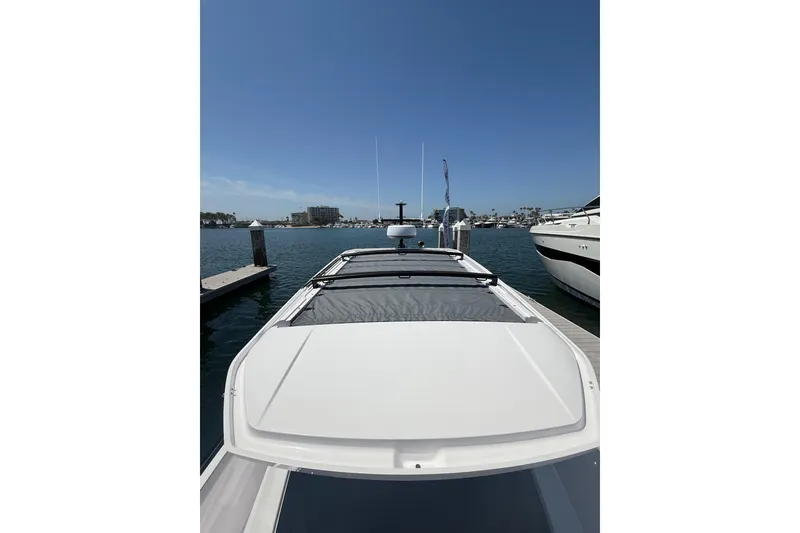 Slide: The Image of 2025 Axopar 29 XC Cross Cabin docked at marina under clear blue sky. - 13
