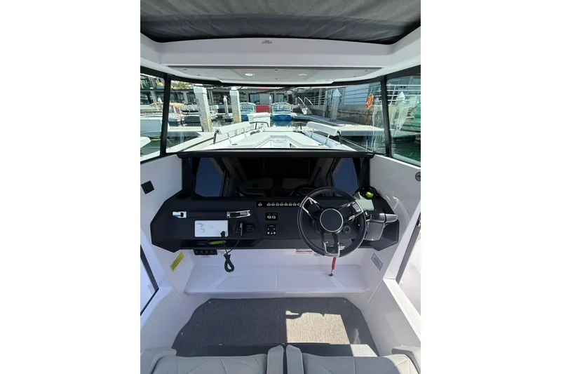 Slide: The Image of 2025 Axopar 29 XC Cross Cabin interior with modern steering and dashboard controls. - 17