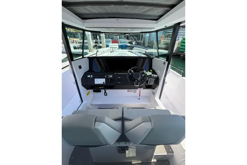 Slide: The Image of 2025 Axopar 29 XC Cross Cabin interior with modern helm and seating. - 18