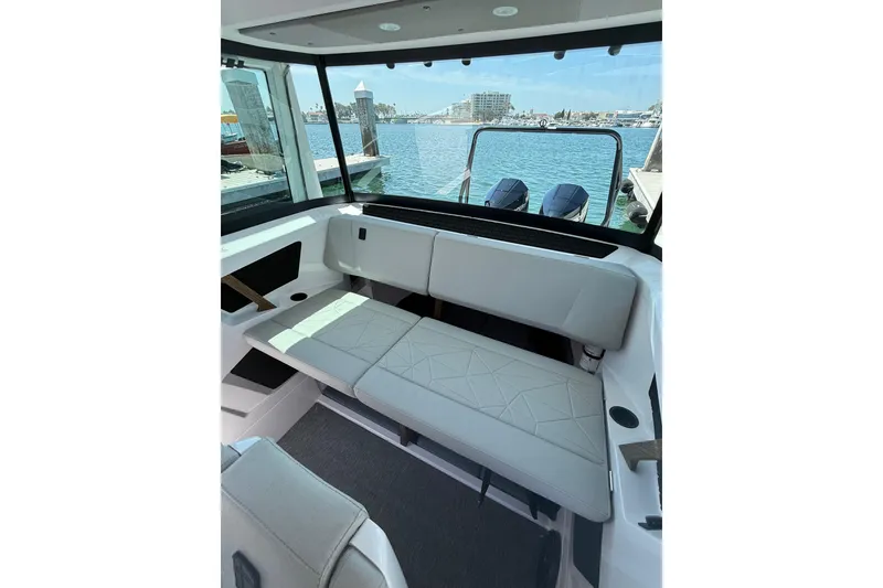 Slide: The Image of 2025 Axopar 29 XC Cross Cabin interior with sleek seating and waterfront view. - 19