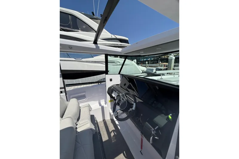 Slide: The Image of 2025 Axopar 29 XC Cross Cabin interior with modern steering and seating. - 22