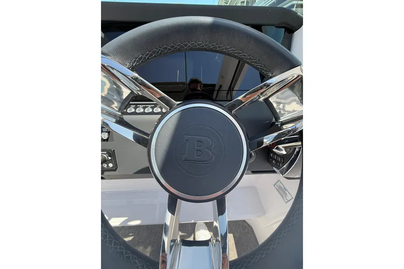 Slide: The Image of Steering wheel of 2025 Axopar 29 XC Cross Cabin boat, featuring sleek design and controls. - 25