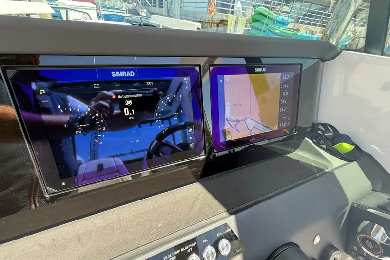 Slide: The Image of 2025 Axopar 29 XC Cross Cabin dashboard with dual Simrad displays showing navigation and controls. - 26