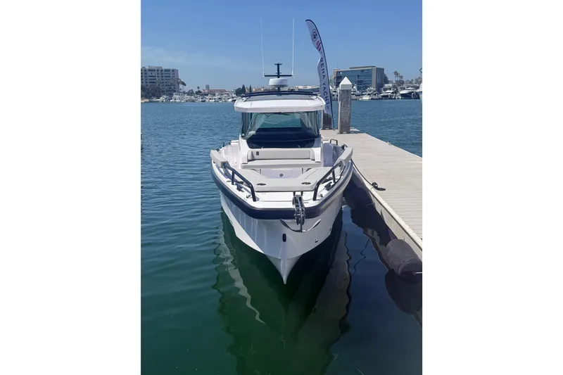 Slide: The Image of 2025 Axopar 29 XC Cross Cabin docked in a marina, showcasing sleek design and modern features. - 3