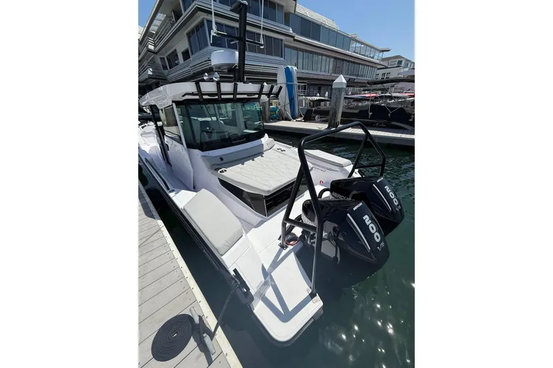 Slide: The Image of 2025 Axopar 29 XC Cross Cabin boat docked with twin Mercury engines. - 4