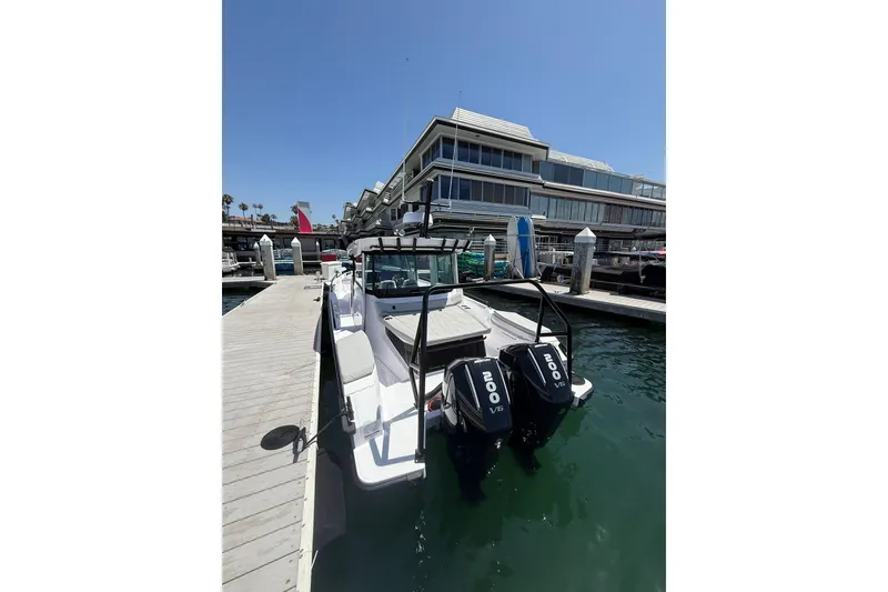 Slide: The Image of 2025 Axopar 29 XC Cross Cabin docked at a marina with twin 200 V6 engines. - 5
